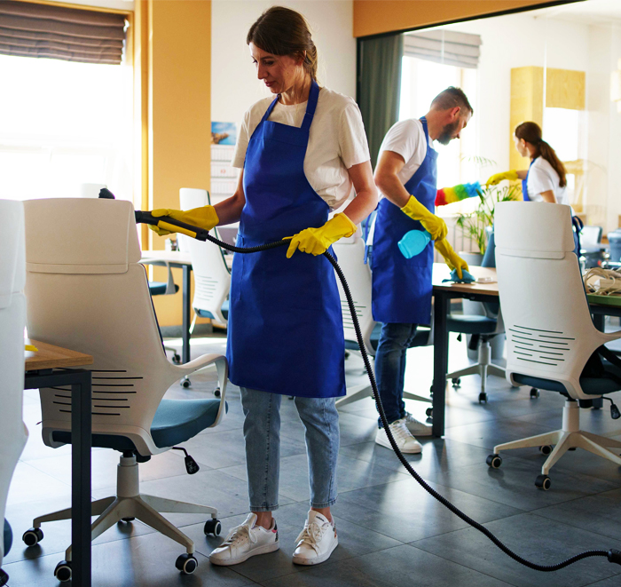 Trained office cleaner disinfecting a meeting room