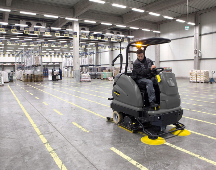 Warehouse cleaner working around racking and high shelving in Wollongong